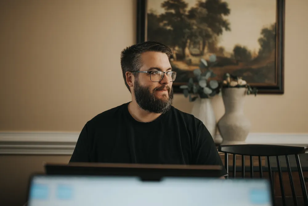 Kyle Segars, DeSoto Spotlight’s Content Director, smiling at his desk